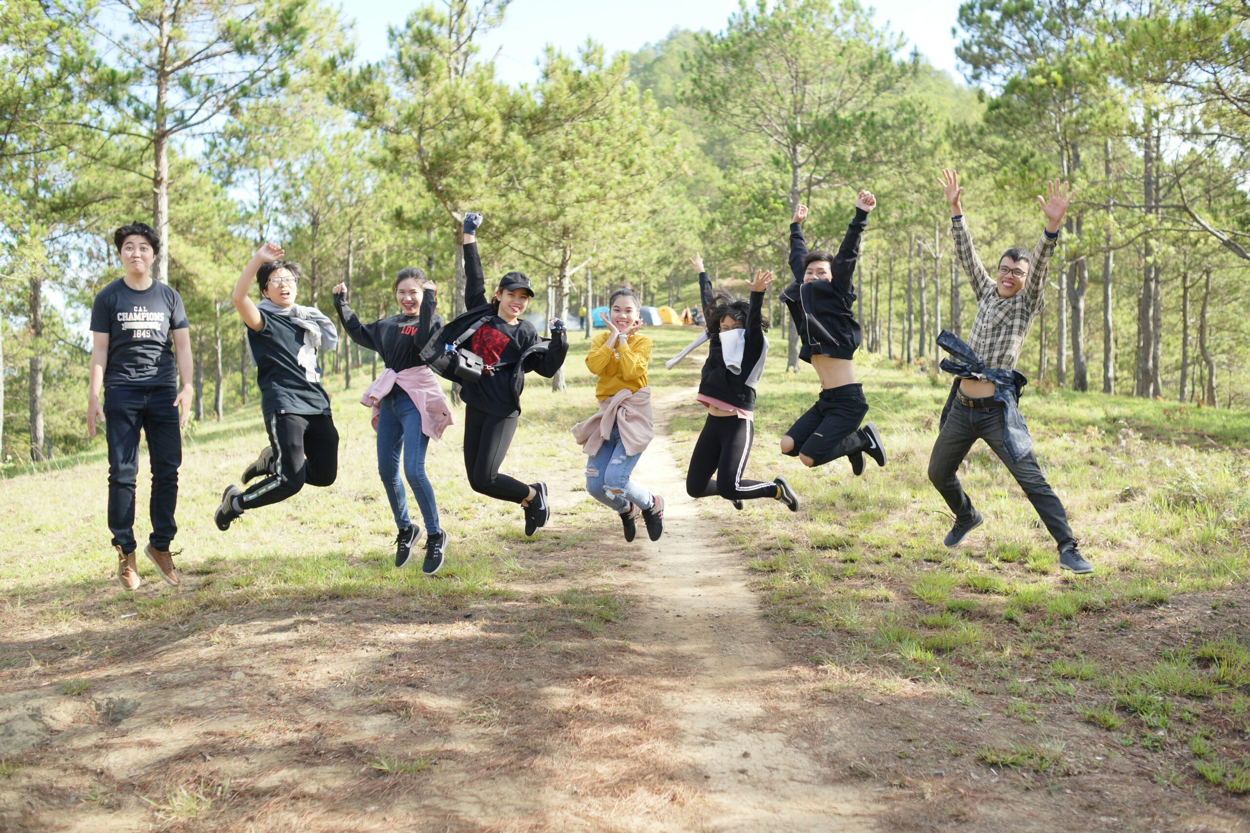 Image of uni open day students jumping for joy in campus garden