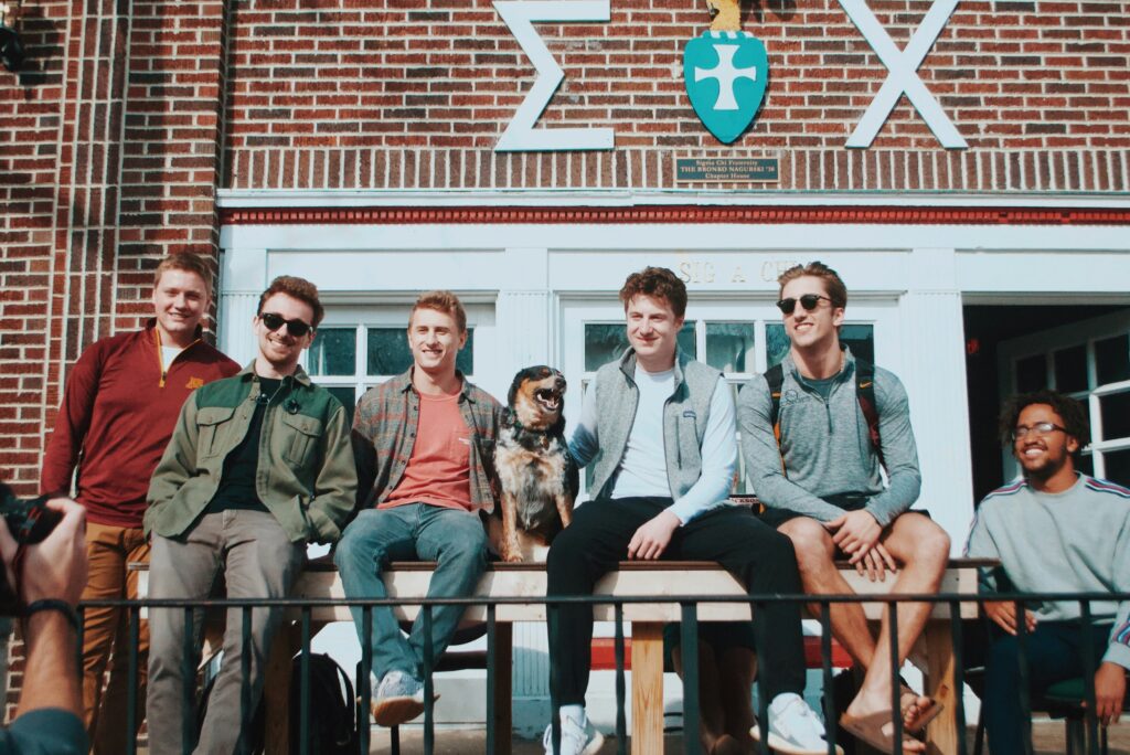 Image of university friends sat outside a campus building at a uni open day