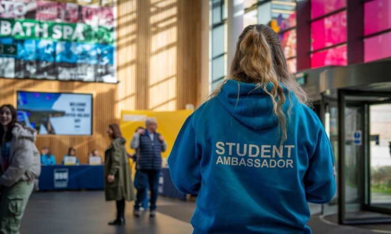 Bath Spa University open day welcome desk student ambassador greeting potential students at campus building